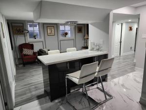 坎布里奇LUXURY 2-BEDROOMS UNIT WITH WIFI, LDR & PARKING.的厨房配有白色的柜台和椅子