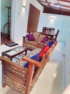 科伦坡Araliya Uyana Residencies Colombo - Entire House with Two Bedrooms的客厅配有木椅和玻璃桌