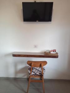 日惹ZEN MOON Hostel的一张木桌、椅子和墙上的电视