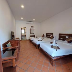 琅勃拉邦Villa Chitchareune 2的一间客房内的四张床