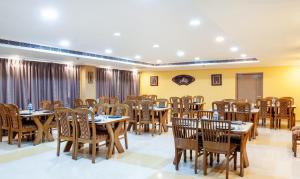 布巴内什瓦尔Treebo Trend Y Hotels Elite - Jagamara的一间在房间内配有桌椅的餐厅