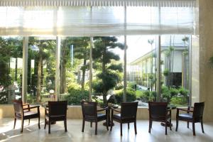 泉佐野關西機場美景花園飯店的一间带桌椅和大窗户的用餐室