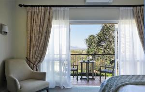 斯泰伦博斯苏佳尔博德庄园酒店的一间带一张床和一把椅子的卧室以及一个阳台