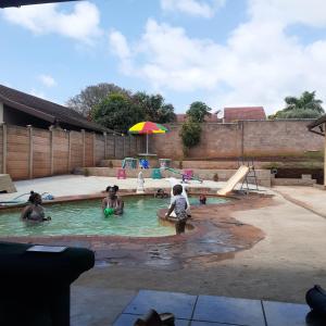 恩潘盖尼Kwesethu Guesthouse的一群人在游泳池玩耍