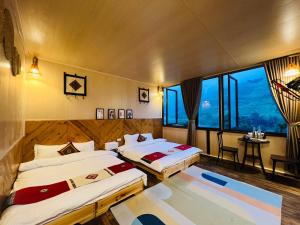 萨帕En Hotel Sapa的酒店客房设有两张床和窗户。