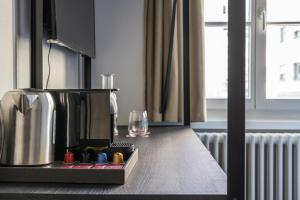 卢塞恩Hotel Goldener Stern - contactless check-in的一个带咖啡壶和玻璃的厨房台面