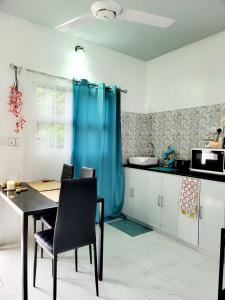 丹格迪Amore Apartment, Maldives的厨房配有桌子和蓝色窗帘