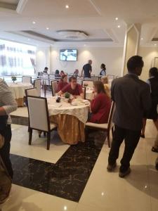 阿克苏姆Armah International Hotel的一群坐在餐厅桌子上的人