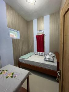塔旺曼谷Villa Cakrawala的一间小卧室,配有一张床和一条红色毛巾