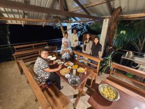 基图尔格勒White Villa Kitulgala的一群人坐在餐桌旁吃着食物