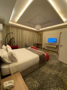 艾卜哈فندق جولدن توليب أبها - GOLDEN TULIP ABHA HOTEl的酒店客房设有一张大床和一台电视。