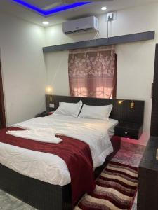 比拉特纳加尔Royalwood City Inn的一间卧室配有一张带红色毯子的大床