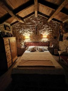 布耶Cottage Casa Vinela的卧室配有一张石墙内的大床