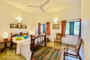 ArawwawalaCaptain's Bungalow, Kandy的一间卧室配有一张床、两把椅子和窗户