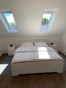 威廉港Apartement Lujzi的卧室配有白色床和2扇窗户