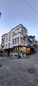 伊斯坦布尔SAND DOOR HOTEL的鹅卵石街道上一座白色的大建筑