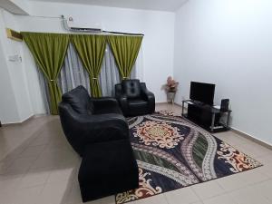 大港Fausal Legacy Homestay Sungai Besar的客厅配有两把椅子和地毯。