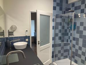 泰沃尔德African Tree的浴室铺有蓝色瓷砖,设有玻璃淋浴间。