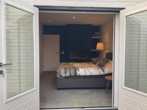 泰沃尔德African Tree的卧室设有一张通过滑动玻璃门的床铺。