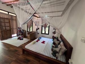 米查维Dreamland Bungalows Michamvi Kae的一间卧室配有两张带蚊帐的床