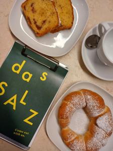 萨尔茨堡Boutique Hotel das Salz的两盘带书和一盘面包的食物
