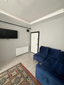 阿瓦诺斯6 şubat apartmanı的客厅配有蓝色的沙发和平面电视。