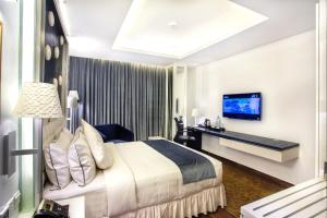 达卡Grace 21 Smart Hotel的配有一张床和一张书桌的酒店客房