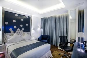 达卡Grace 21 Smart Hotel的酒店客房,配有一张床和一张蓝色椅子