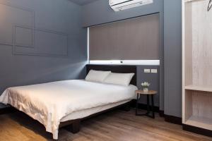 台南EasyLiving的卧室内的一张床铺,卧室内有蓝色的墙壁