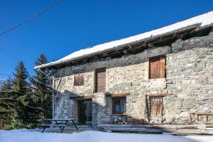 瓦卢瓦尔Chalet Chez Maxime Hameau l’Archaz Valloire的石头建筑,前面设有野餐桌