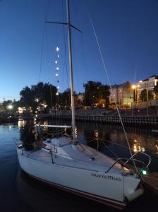 里加Botnia Mini Racer的夜间坐在水中的帆船上的人