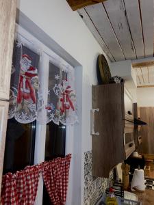 KrynkiOzierański Raj "Pod rzeźbami"的厨房的窗户上装饰有圣诞装饰