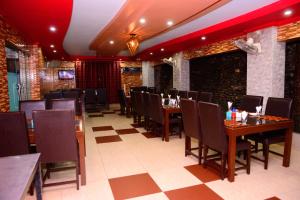 穆扎法拉巴德Mir Continental Hotel & Restaurant的餐厅设有木桌、椅子和红色天花板