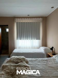 洛斯莫莱斯Hotel Termas Lahuen-Có的配有窗户的酒店客房内的两张床