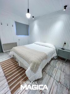 洛斯莫莱斯Hotel Termas Lahuen-Có的白色卧室配有床和桌子