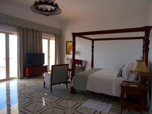 Jasmine Bay Hotel & Spa的一间卧室配有一张大床和电视