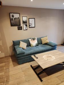 昂古莱姆LaMaisonnette_au_36的客厅配有蓝色的沙发和茶几