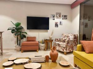 赫尔格达Glamorous 2BR/ Free Beach & Pool Access @ Mangroovy, El Gouna的客厅配有家具和平面电视