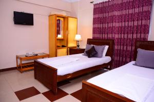穆扎法拉巴德Mir Continental Hotel & Restaurant的一间酒店客房,设有两张床和电视
