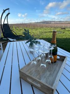 迪斯Douceur champenoise的一张带酒杯的木桌和一瓶