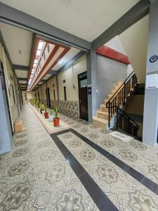 pondok Syariah Hadikusuma的一条空的走廊,铺着瓷砖地板,设有楼梯