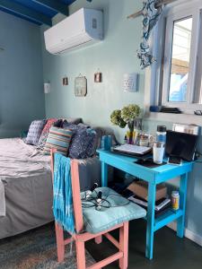 乌蒂拉Dockside Utila Ocean front suites的一间卧室配有蓝色的书桌和一张带笔记本电脑的床。