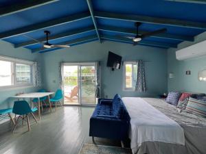 乌蒂拉Dockside Utila Ocean front suites的蓝色卧室,配有床和桌子