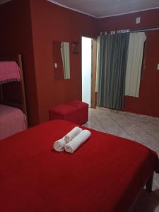 伊瓜苏港RESIDENCIAL LOS AMIGOS的酒店客房,设有两张带红色墙壁的床