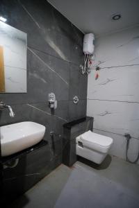 艾哈迈达巴德Hotel Suncity的浴室配有白色水槽和卫生间。