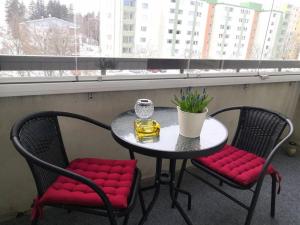科沃拉Valoisa & tilava 3.krs kaksio, lasitettu parveke的一张桌子、红色软垫椅子和一张桌子及一个窗口