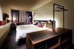 布鲁塞尔pentahotel Brussels City Centre的酒店客房设有一张大床和一张书桌。