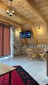 斯库台Windmill Shkodra Gesthouse Camping & Grill的客房设有木制天花板和电视。