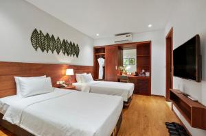 河内Classic Hotel Hanoi的酒店客房设有两张床和一台平面电视。