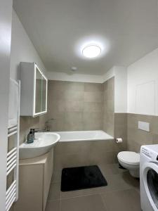 布拉迪斯拉发SkyNest B204的带浴缸、盥洗盆和卫生间的浴室